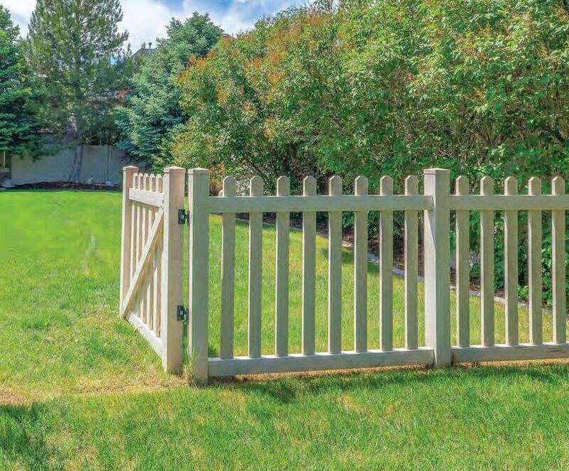 Tan vinyl scalloped picket fence with a walk gate
