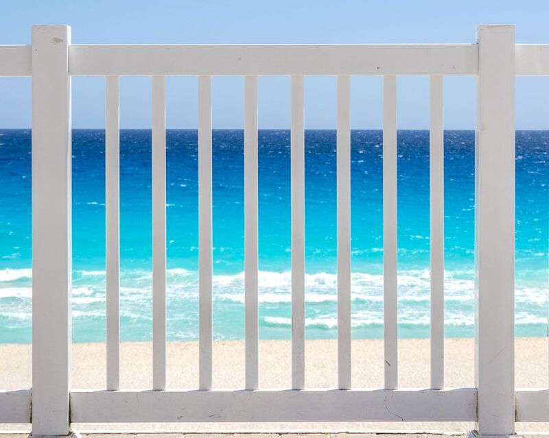 White vinyl closed picket fence at an oceanfront overlook