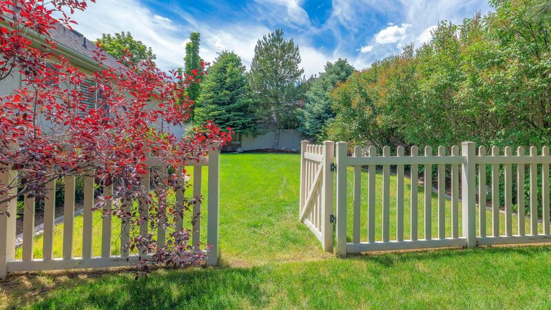 Tan vinyl picket fence with three-inch spacing and a walk gate