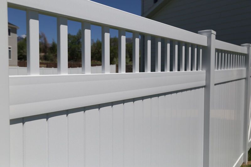 Close detail of a white vinyl privacy fence picket topper