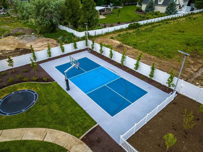Aerial view of a white vinyl privacy fence around a backyard sport court
